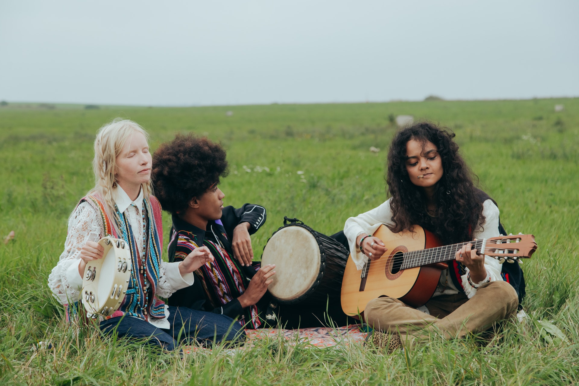 Gruppe jugendlicher machen Musik auf einer Wiese