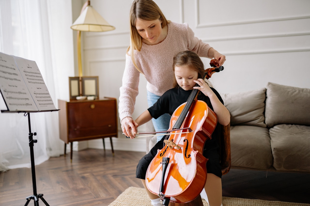 Learning the cello in music school, private music teacher shows how to do it