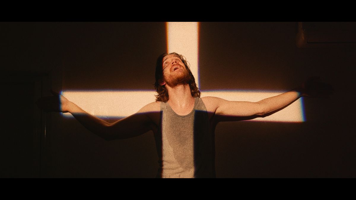 Licht in Kreuzform scheint auf Mann Bo - Beitragsbild zum Thema: Bo Burnham: Inside