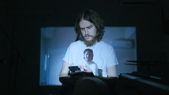 Mann mit Bart am Handy - Beitragsbild zum Thema: Bo Burnham: Inside