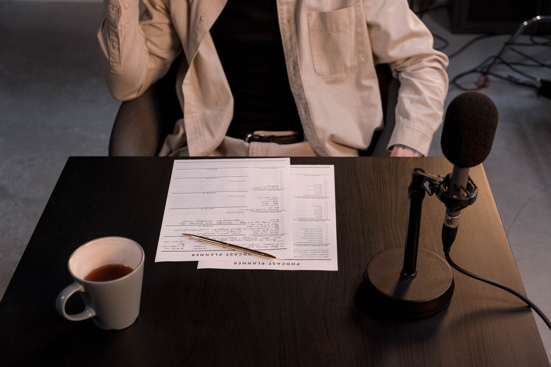 Mann in Beige Hemd vor einem Tisch mit Papier und Stift