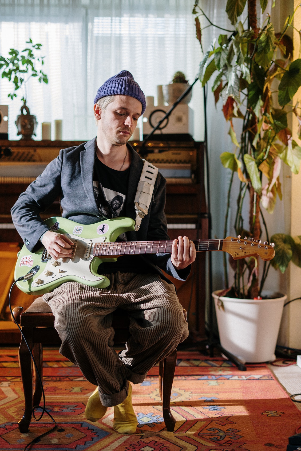 Young man plays stratocaster electric guitar on the topic: find the best electric guitar strings