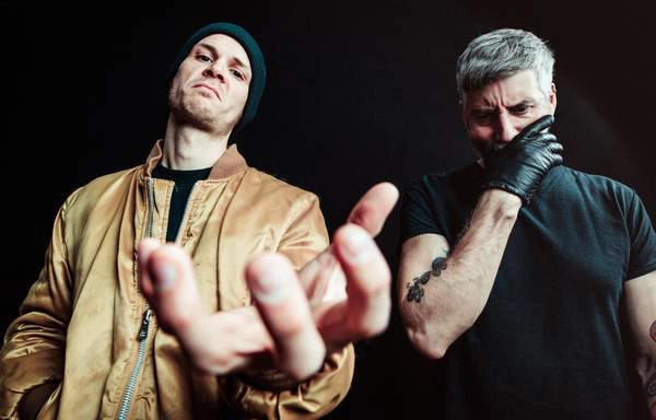 Ein Bild der Band Mantar. Die beiden Männer schauen ernst, einer hält sich die Hand vor den Mund, der andere streckt seine nach vorne