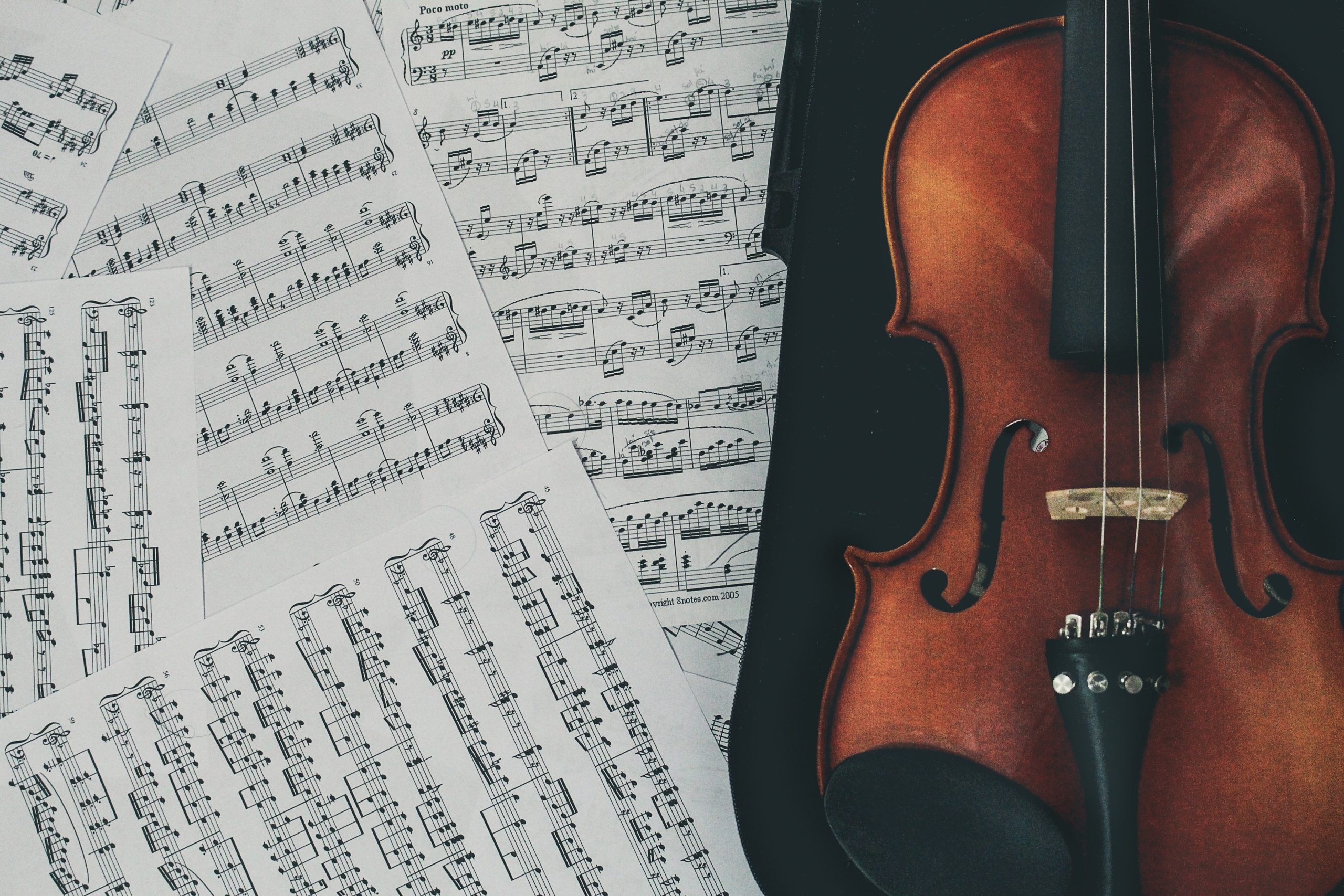 Eine Violine liegt neben Notenblättern