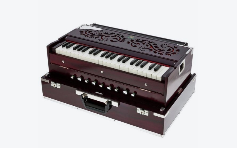 Das Harmonium ist ein Tasteninstrument, das mit einer Hand bedient wird, während die andere die Blasebälke bedient